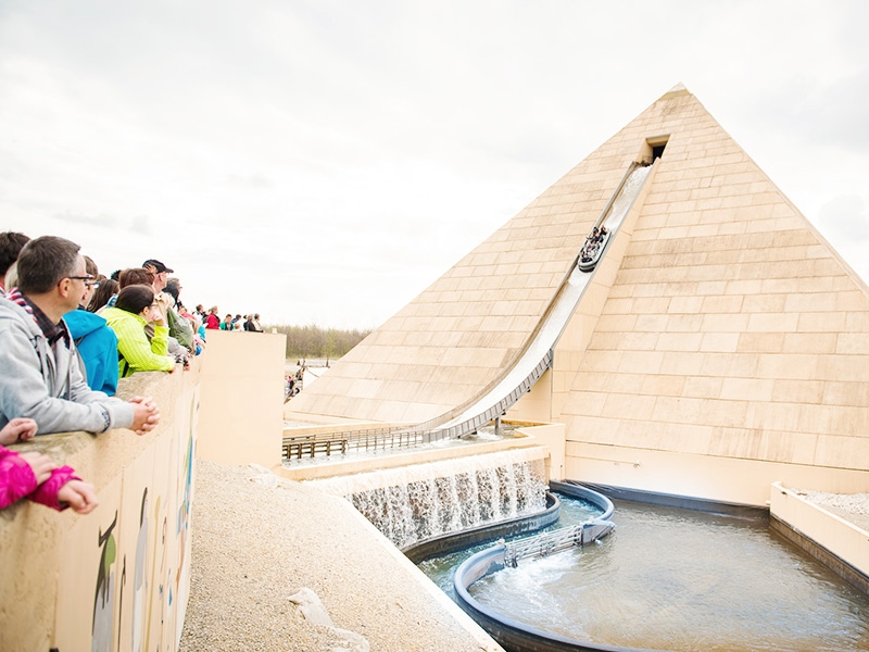 Eine Gruppe Menschen vor einer Pyramiden-Wildwasserbahn