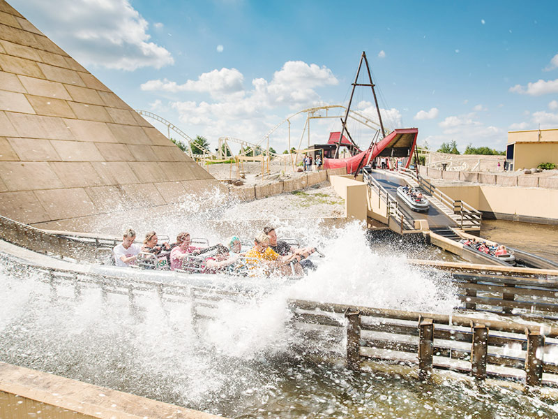 Menschen kommen im Wasser einer Wasserrutsche an.