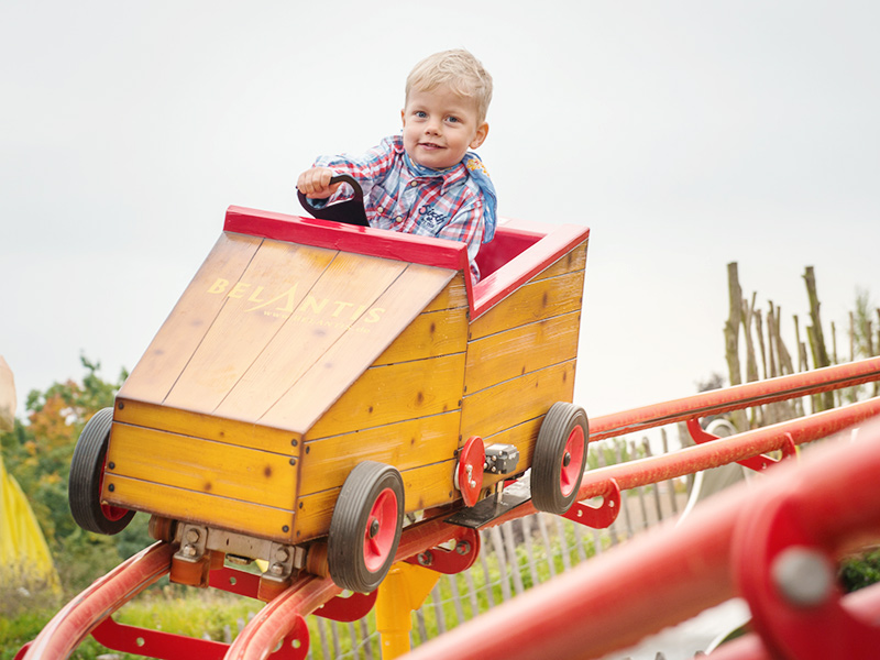 Kind auf einer Kinderachterbahn